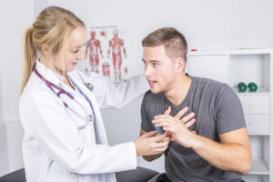 Doctor helping a man with his inhaler