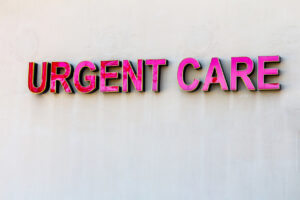 Red urgent care sign on beige wall
