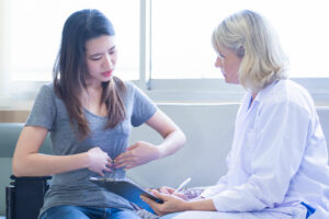Senior female doctor giving consultation to a patient with abdomen pain